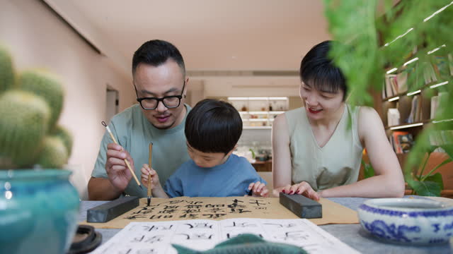 Parents practice Chinese calligraphy with their children
