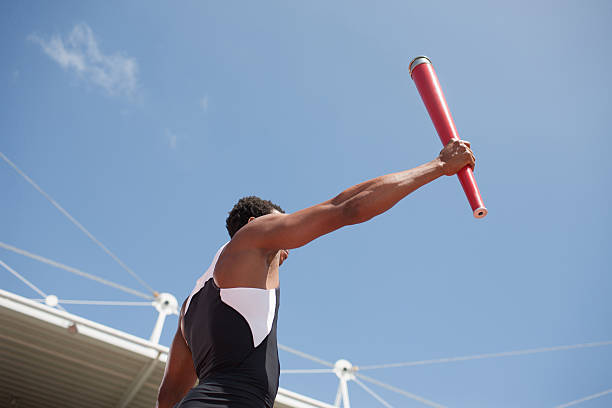 Runner running with torch on track  mens track stock pictures, royalty-free photos & images