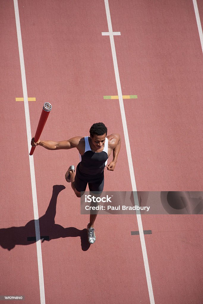 Corredor corriendo con linterna en pista - Foto de stock de Acontecimiento deportivo internacional libre de derechos