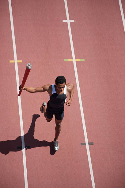 corredor corriendo con linterna en pista - acontecimiento deportivo internacional fotografías e imágenes de stock