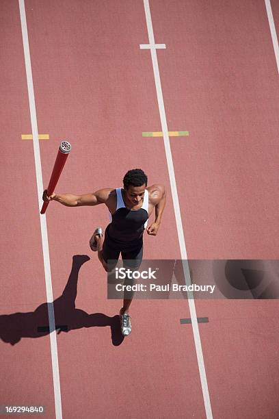 Corredor Corriendo Con Linterna En Pista Foto de stock y más banco de imágenes de Acontecimiento deportivo internacional - Acontecimiento deportivo internacional, Atleta - Papel social, Antorcha