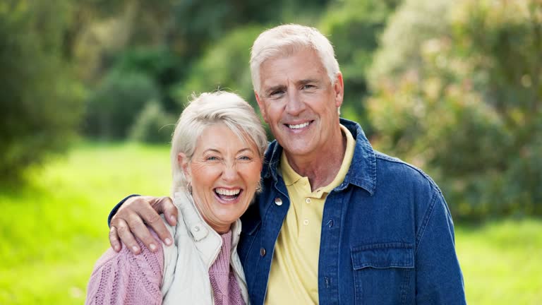 Face, funny and senior couple in nature, having fun and bonding together. Portrait, happy and elderly man and woman laughing at comedy, smile and enjoying quality time outdoor on vacation with love.