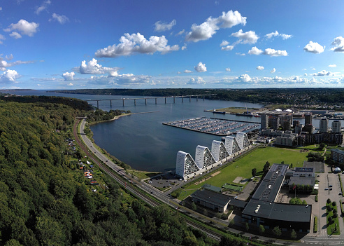 Aerial panoramic view of the harbour and downtown area with mordern architectural vaweshaped building in the foreground on a sunny day in Vejle, Jylland, Denmark