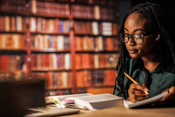istock Young woman reading a book and writing notes when studying for exam 1693026975
