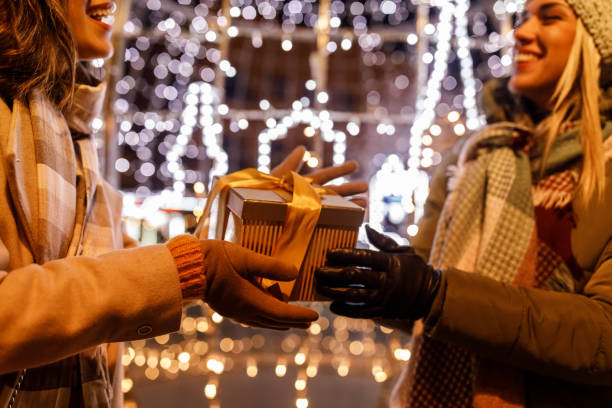 istock Caring young woman surprising her girlfriend with a Christmas gift box 1693029313