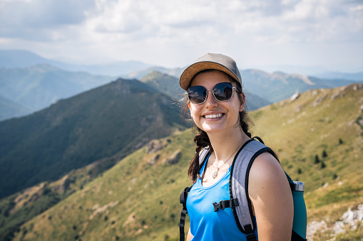 Portrait of a smiling woman on a hike in the mountains.