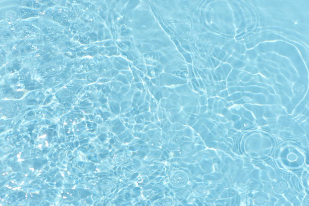 istock Defocus blurred transparent blue colored clear calm water surface texture with splashes reflection. Trendy abstract nature background. Water waves in sunlight with copy space. Blue watercolor shine. 1693041837