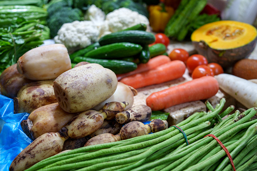 A background of colorful vegetables symbolizes healthy eating, vegetarianism, and veganism.
