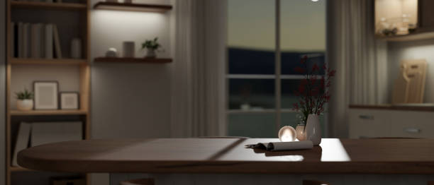 istock Empty mockup space on a wooden tabletop in a modern living room at night. 1693081129