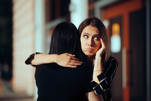 Backstabbing toxic girlfriend embracing someone with bad intentions