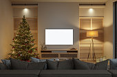 Modern Living Room Interior With Christmas Tree, Ornaments, Sofa And Smart Tv Mockup With White Screen At Night