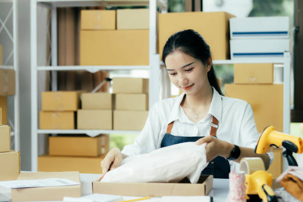 istock Small business owner packing clothes in the box at workplace. 1693193441