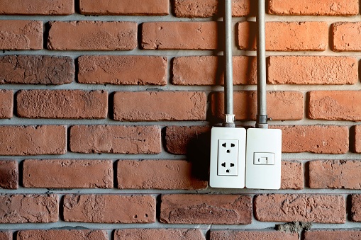 Power plug on brick wall background with copy space