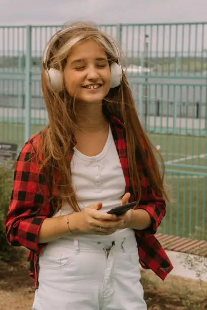 young girl listen music walking outdoors