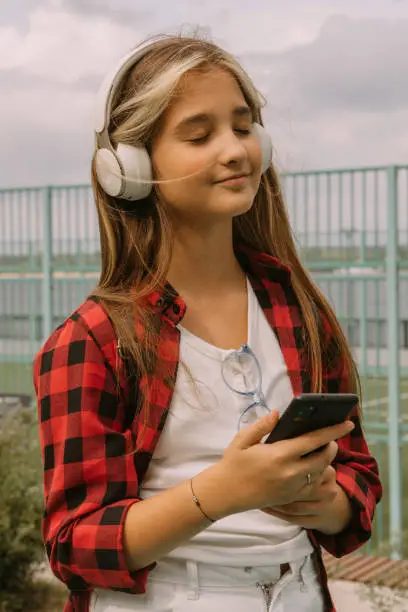young girl listen music walking outdoors