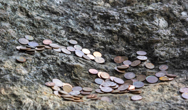 istock Small coins on a stone. Ritual for being rich 1693198435