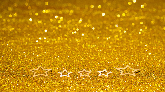 Christmas stars on shiny golden background.