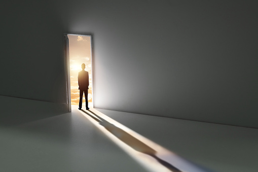 Businessman standing in front of open door