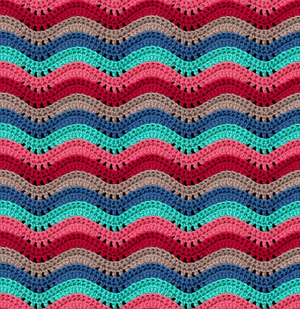 istock Seamless knitted pattern in the form of openwork waves is crocheted with threads of bright colors. Cotton yarn. 1693212429