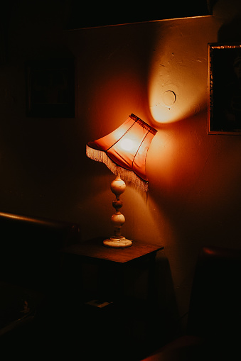 Vintage lamp giving yellow light on the wall through the sliding lamp shade