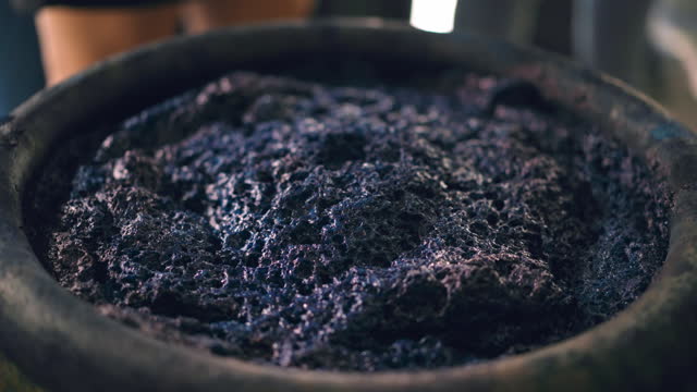 Close up shot of natural based dark blue pigment in a jar for dyeing the cloth with eco-friendly process, traditional dye preparation for dyeing the cloth in the rural area for local people lifestyle study