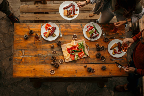 istock High angle view of friends setting up and eating at the dining table. 1693214775