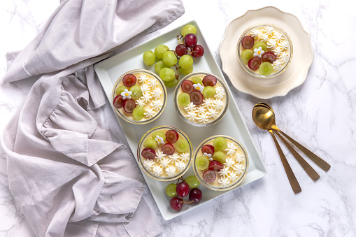 Delicious cheesecake with grapes and whipped cream on marble board