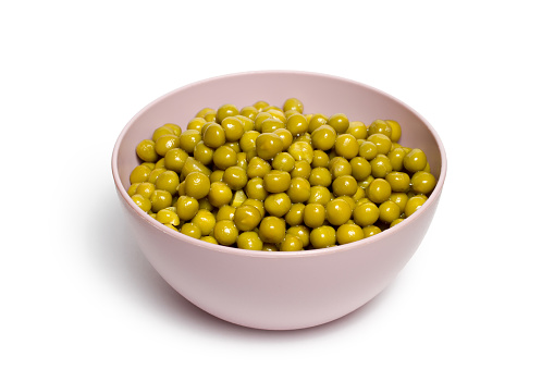 Green peas in a plate on a white background. Canned green peas. With a shadow.