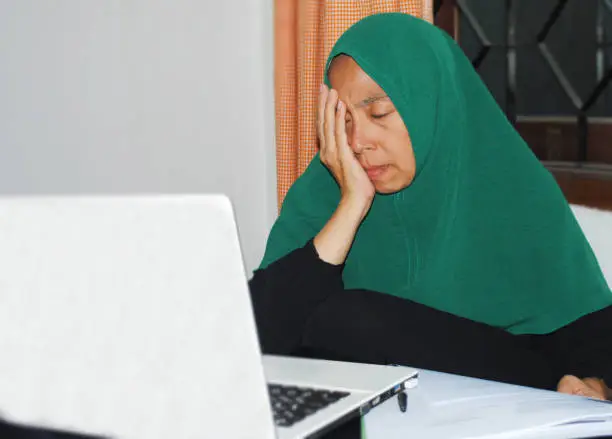 Photo of Hijab woman in expression of symbolising the suspicion caused by the manipulative nature of financial fraud.