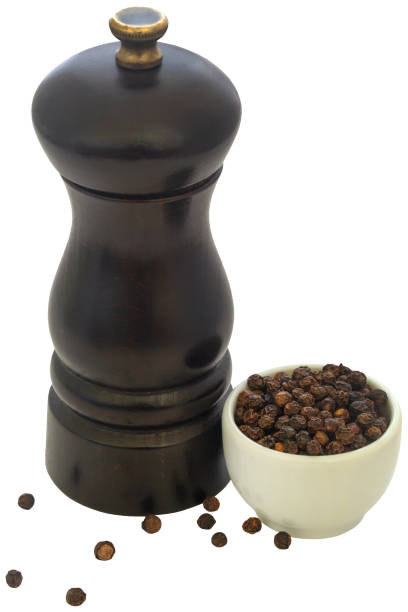 Wooden pepper mill with black pepper closeup