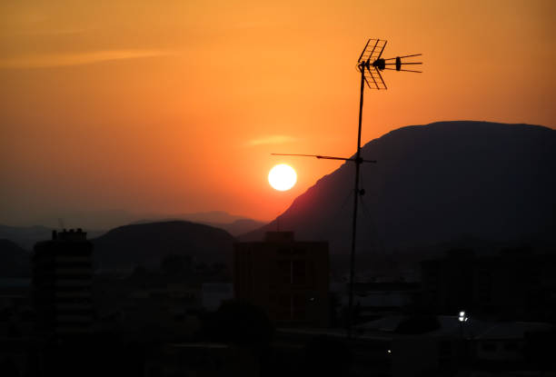 Sunset over the mountains with an antenna stock photo