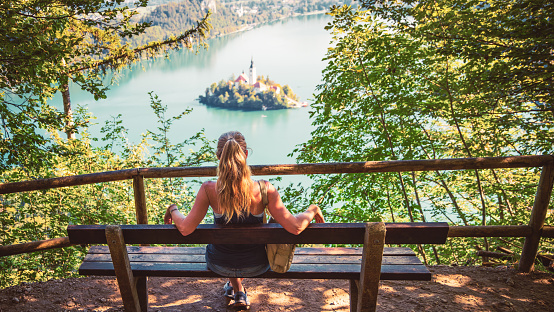Traveler girl enjoying panoramic view of island bled lake- tourism, vacation, destination Slovenia