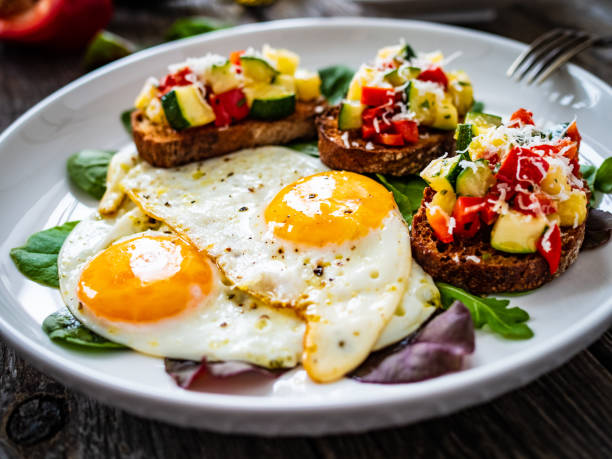 istock Continental breakfast -   fried eggs and bruschetta with fresh vegetables on wooden table 1693335802