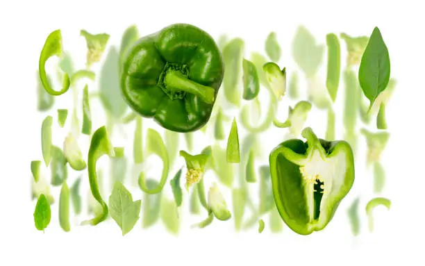 Abstract background made of Green Bell Pepper vegetable pieces, slices and leaves isolated on white.