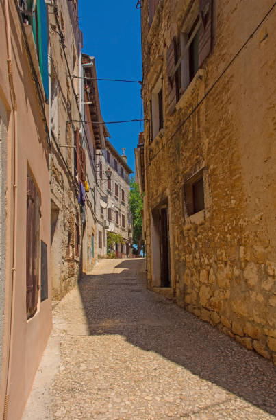 hinterstraße in der altstadt von rovinj, kroatien - stone narrow street blue sky back alley stock-fotos und bilder