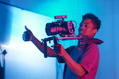African American professional cameraman shooting photo for content in studio