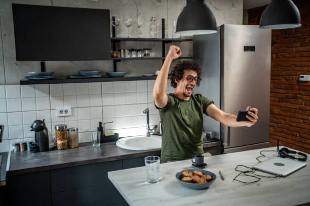 istock Smiling middle aged man playing video games on his smartphone 1693360540