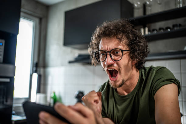 istock Smiling middle aged man playing video games on his smartphone 1693364793
