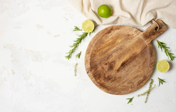Empty wooden round board on white stone kitchen table top stock photo
