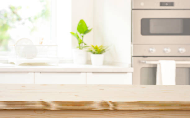 istock Wood table top on blurred kitchen equipment and window background 1693366755