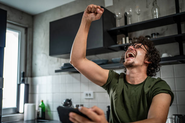 istock Smiling middle aged man playing video games on his smartphone 1693366762