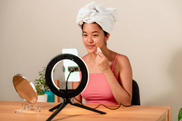 istock female asian blogger Using Gua Sha Stone making a tutorial video on her mobile phone at home 1693394741