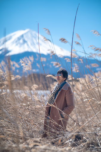 Asian senior woman in the field travelling Mt. Fuji, Japan