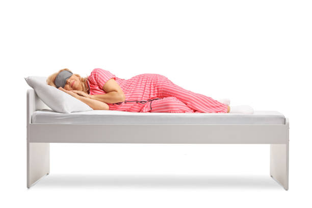 istock Woman in pajamas sleeping on a bed with a sleeping mask 1693414012