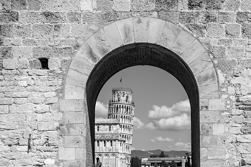View of the Leaning Tower of Pisa from the city gate in 
black and white photography