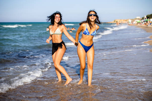 istock Two pretty young woman having fun on the seaside 1693426930