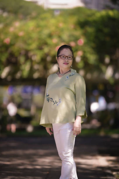 elderly asian woman over 60 years old in the park, independent and confident elderly woman. - independence lifestyles smiling years imagens e fotografias de stock