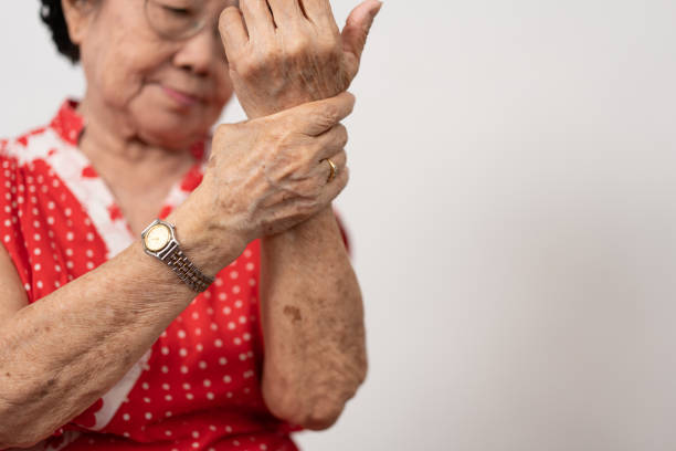 高齢のアジア人女性患者は、関節リウマチによる手のしびれる痛みに苦しんでいます。年配の女性が手首の痛みで手をマッサージする。関節痛、関節リウマチ、手の問題のコンセプト。 - arthritis senior adult rheumatoid arthritis sadness ストックフォトと画像