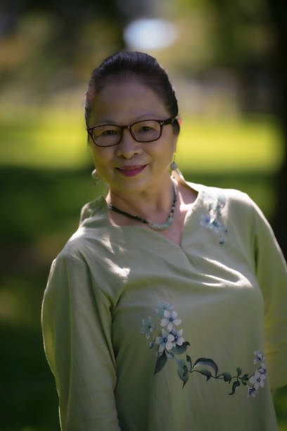 elderly asian woman over 60 years old in the park, independent and confident elderly woman. - independence lifestyles smiling years imagens e fotografias de stock