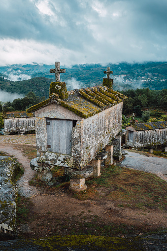 Espigueiros (Hórreos). Typical stone corn dryers (racecards or granaries lifted to be protected against rodents) crowned with crosses on the stone hill in Soajo. Peneda-Geres park. Minho, Portugal